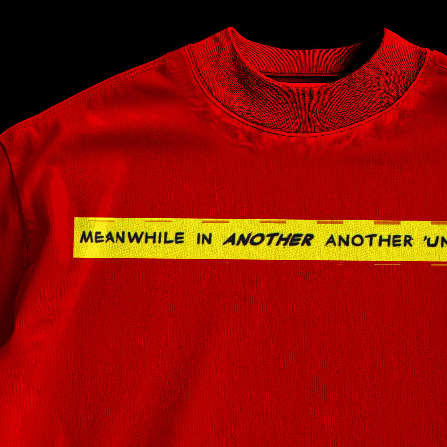 Close-up of yellow comic banner reading Meanwhile In Another Another Universe on amhype red graphic tee front