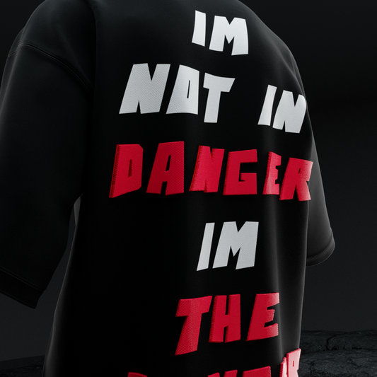 Close-up back of amhype Breaking Bad oversized tee — 3D puff raised I'm Not In Danger I'm The Danger typography in white and red on black terry