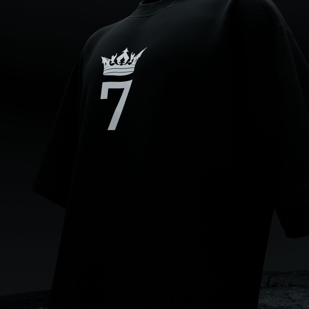 Close-up front of amhype MS Dhoni Crown 7 oversized tee — white flame crown number 7 logo on black heavyweight cotton