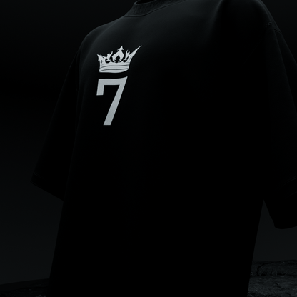 Close-up front of amhype MS Dhoni Crown 7 oversized tee — white flame crown number 7 logo on black heavyweight cotton